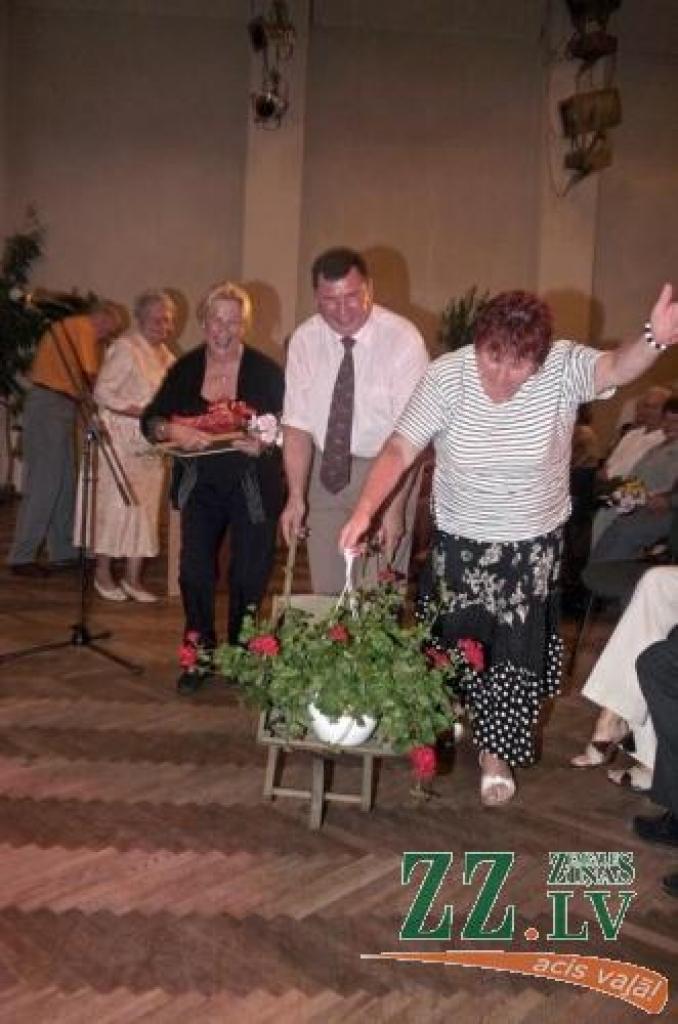 Vircavas pagasta sakoptākās individuālās mājas «Nilseni» saimniece Elena Annelisa Mortensena (trešā no labās) saņem pārsteigumu - koka ķerru ar ziediem.