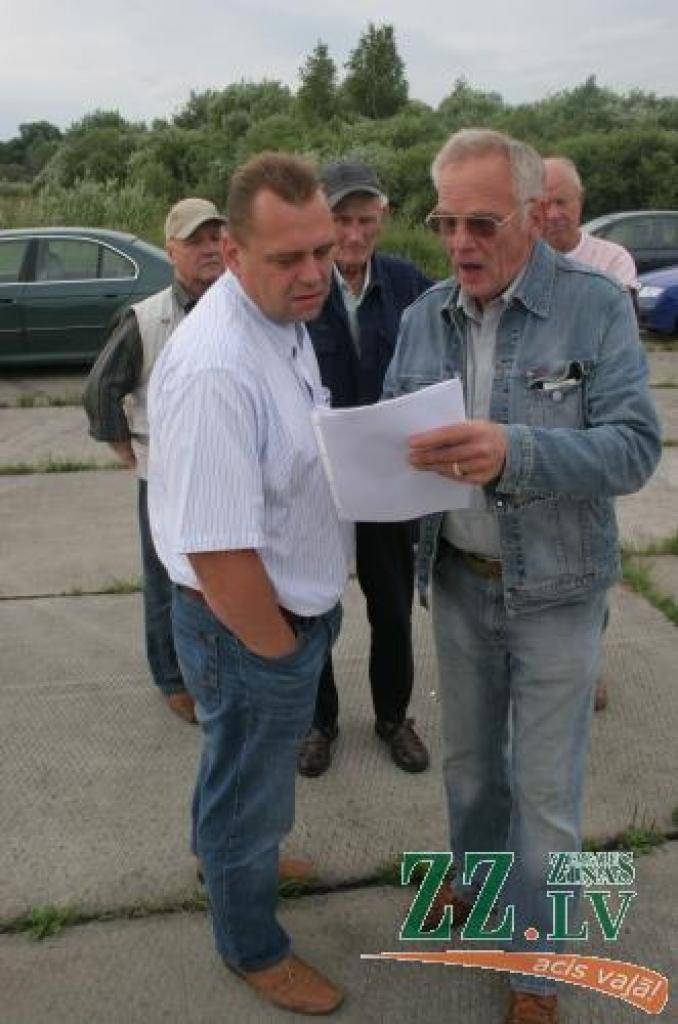 Diskutē (priekšplānā) A.Lūsis un lidotājs Jānis Pladars; fonā redzams arī leģendārais aviators Huberts Štekelis.