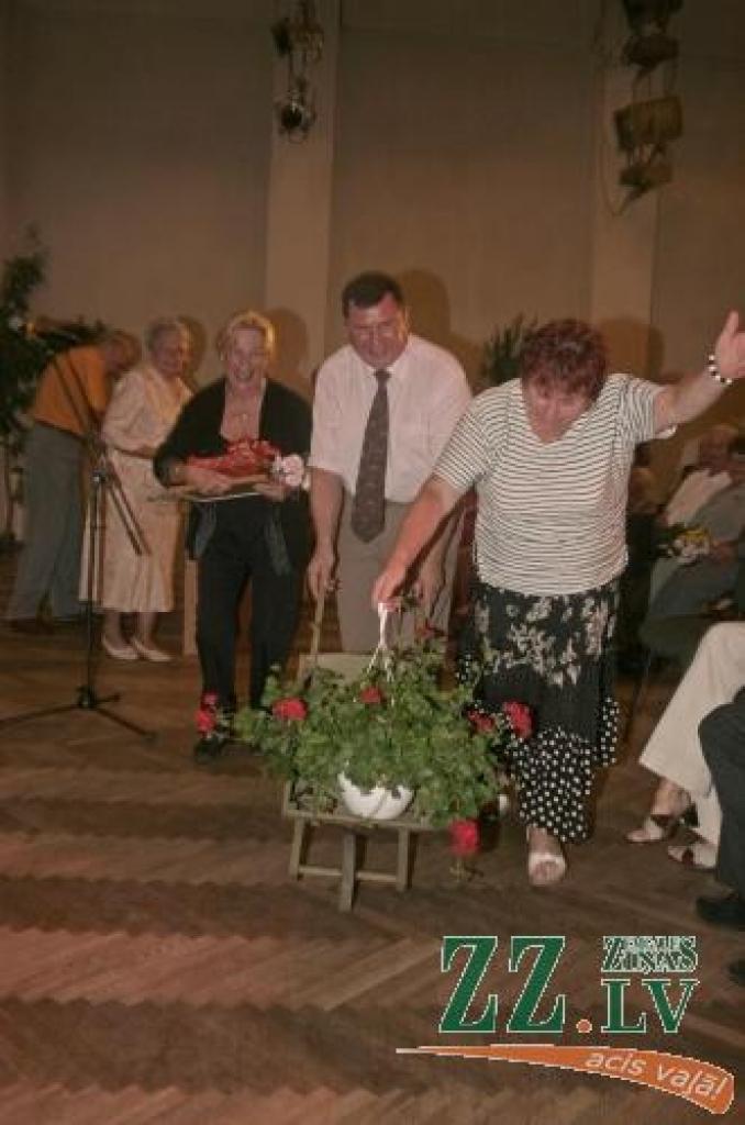 Vircavas pagasta sakoptākās individuālās mājas «Nilseni» saimniece Elena Annelisa Mortensena (trešā no labās) saņēmusi oriģinālu sveicienu - koka ķerru ar ziediem.