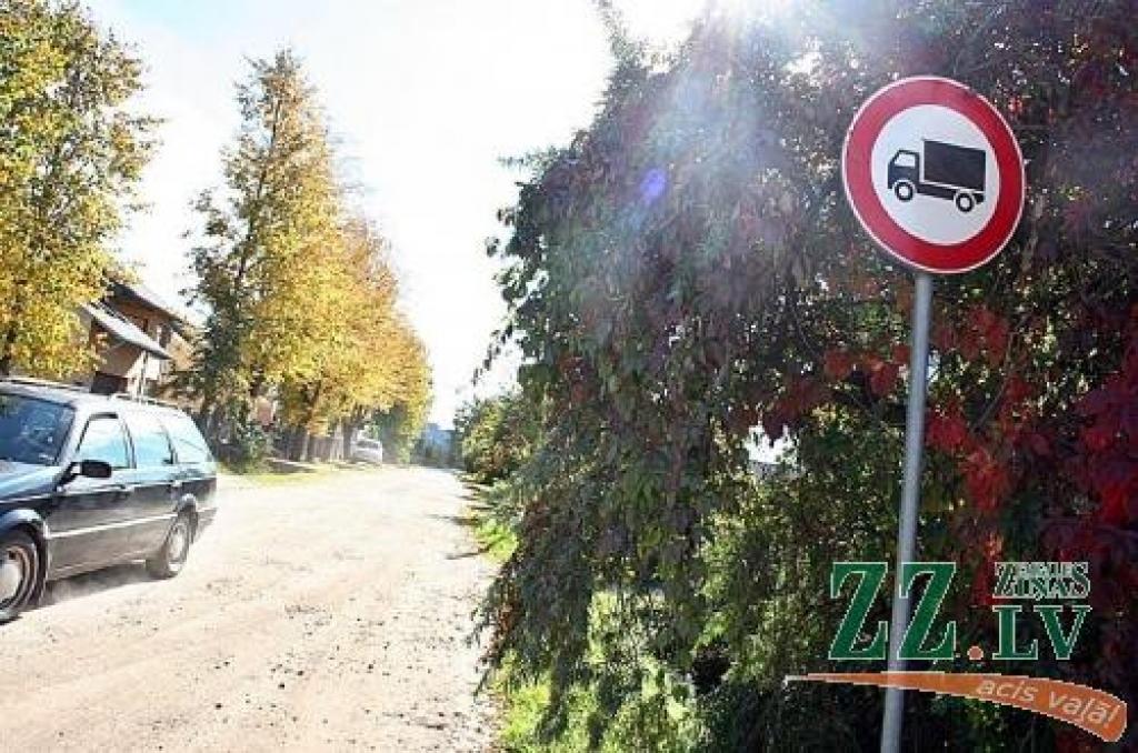 Lāču un Platones ielas krustojumā ceļa norāde ar aizliegumu braukt kravas autotransportam šovasar bija pamatīgi apaugusi ar mežvīteni, tādēļ kļuvusi grūti saredzama. Aģentūras «Pilsētsaimniecība» darbinieki to no augiem atbrīvoja, uzsverot, ka dažviet vainojami savrupmāju īpašnieki, kas ļauj augiem «izkāpt» ārpus sētas un pārņemt ceļa zīmes.
Autors: Agris Samcovs.