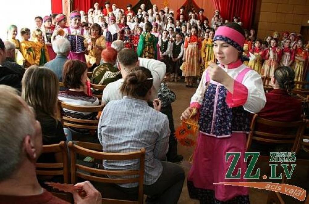 Deju kolektīva «Ija» dalībniece dala kaklā karināmos saules simbolus.
Autors: Agris Samcovs.