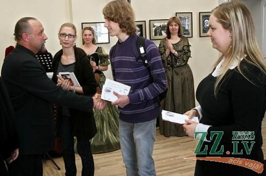 Fotomākslinieks Juris Zēbergs apbalvo pilij veltītā fotokonkursa uzvarētājus - (no kreisās) Zandu Kmito, Kristapu Hercu un Ingu Galoburdu.
Autors: Agris Samcovs.