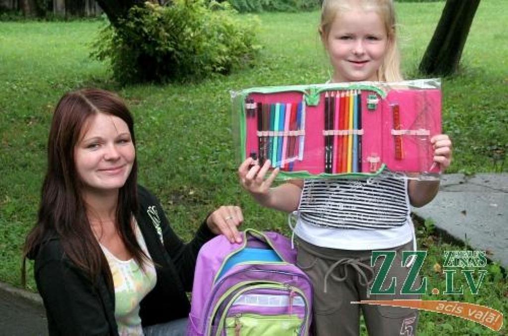 Sanita Babre no Bramberģes ar meitiņu Tīnu, kura bija to četrpadsmit laimīgo skaitā, kam Sarkanā Krusta Jelgavas komiteja dāvāja skolas somu un mācībām noderīgas lietas. 
Autors: Māra Ozola.