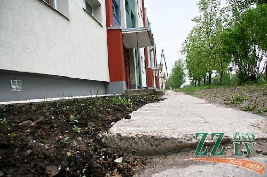Renovētās 4.līnijas 1.mājas apkaimē kopš pavasara nekas daudz nav mainījies. Celiņu plātnes pēc celtnieku rosības arvien šķībi greizas, bet grūti uz darbiem pierunājamā Nekustamā īpašuma pārvalde zālienu neatbilstošā laikā vasaras sākumā iesējusi nesagatavotā augsnē, tādēļ veseliem pleķiem tas nemaz nav sadīdzis, atklājot akmeņus un citus gružus, kas tur palikuši pēc renovācijas. 
Autors: No «Ziņu» arhīva.