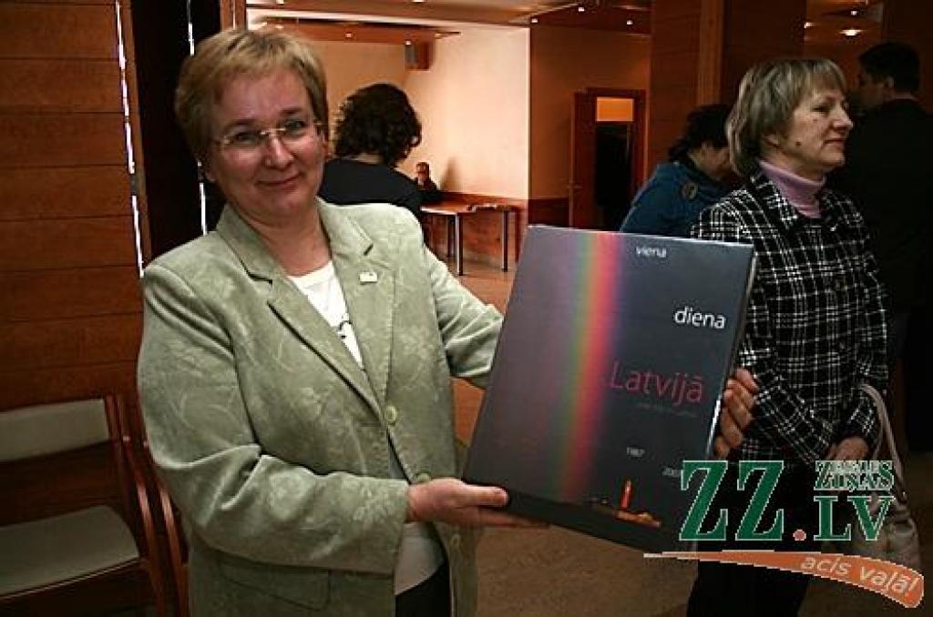 Jelgavas Zinātniskās bibliotēkas direktores vietniece Dzintra Punga ar grāmatu krātuvei uzdāvināto fotoalbuma «Viena diena Latvijā» eksemplāru.
Autors: Agris Samcovs.