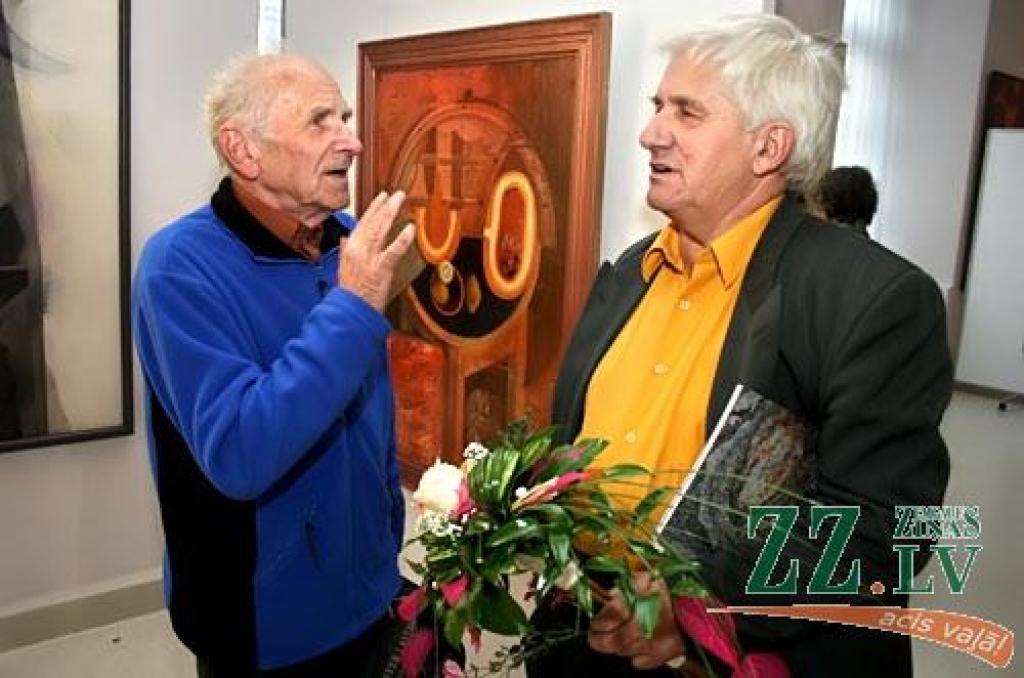 Tēlnieks Indulis Ranka (no kreisās) sveic izstādes autoru Pēteri Postažu.
Autors: Agris Samcovs.