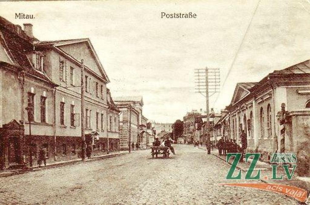 Kā šajā sērijā ierasts, gan vecajā, gan jaunajā attēlā redzam aptuveni vienu un to pašu ielas posmu ar Pasta ielas un Raiņa (agrāk Annas) ielas krustojumu, pie kura celtās pasta ēkas visos laikos devušas ielai tās nosaukumu.

Vecajā attēlā...