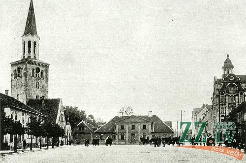 Vecajā attēlā pāri priekšplānā esošajam Tirgus laukumam redzam pilsētas ainavu, kuras robežas – Sv.Trīsvienības baznīcas tornis un Akadēmijas (agrāk Palejas) iela – atrodamas arī mūsdienās.

Labajā stūrī aplūkojams zudušais Jelgavas...