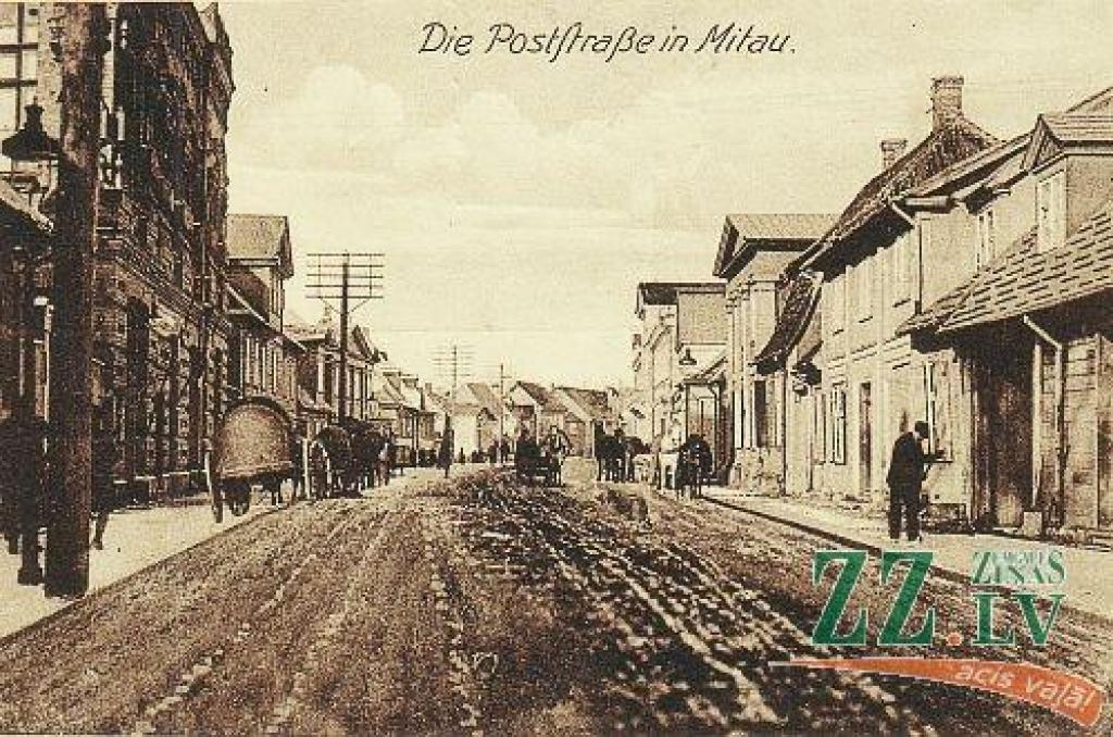 Vecajā un jaunajā attēlā redzam vienu un to pašu Pasta ielas posmu starp Dīķa (tagad Sudrabu Edžus) ielu un Annas (Raiņa) ielu, ar skatu virzienā uz Lielo ielu. Abos attēlos tālumā redzams krustojums ar tagadējo Raiņa ielu.

Jelgavas...