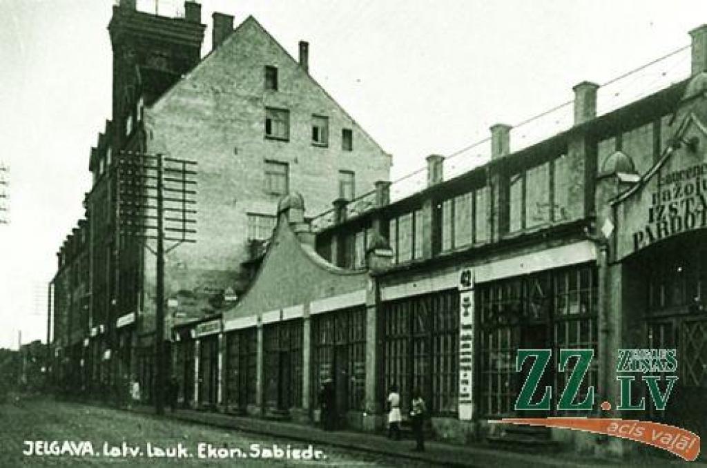 Tur, kur mūsdienās ir tirdzniecības centrs «Vivo centrs» ar veikalu «Rimi», arī pirmskara Jelgavā un  agrākos laikos bijusi tirdzniecības un biznesa apbūve.

Vecajā attēlā, pa kreisi redzamā, lepnā augstceltne ir Latvijas lauksaimnieku...