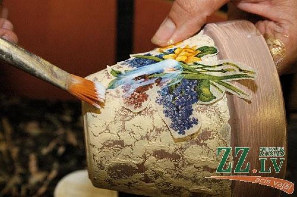 Pirmais solis – grunts uzklāšana neglazētam podiņam. Tad ar akrila krāsu noklāj pamatu. Izgriezto motīva augšējo slāni apstrādā ar dekupāžas līmi. Beigās vairākas kārtas nolako, pēdējā var būt matēta.
Autors: Dainis Ģelzis