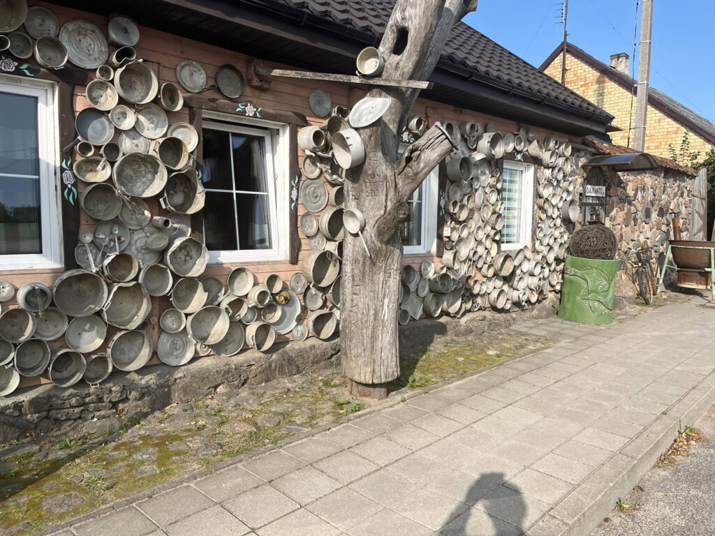 Pusceļā no Jelgavas uz Eltišķiem – Žagarē – par lietuviešu radošumu liecināja dīvaini ar veciem katliem apsista māja, kurai glīti bija atjaunots jumts. 