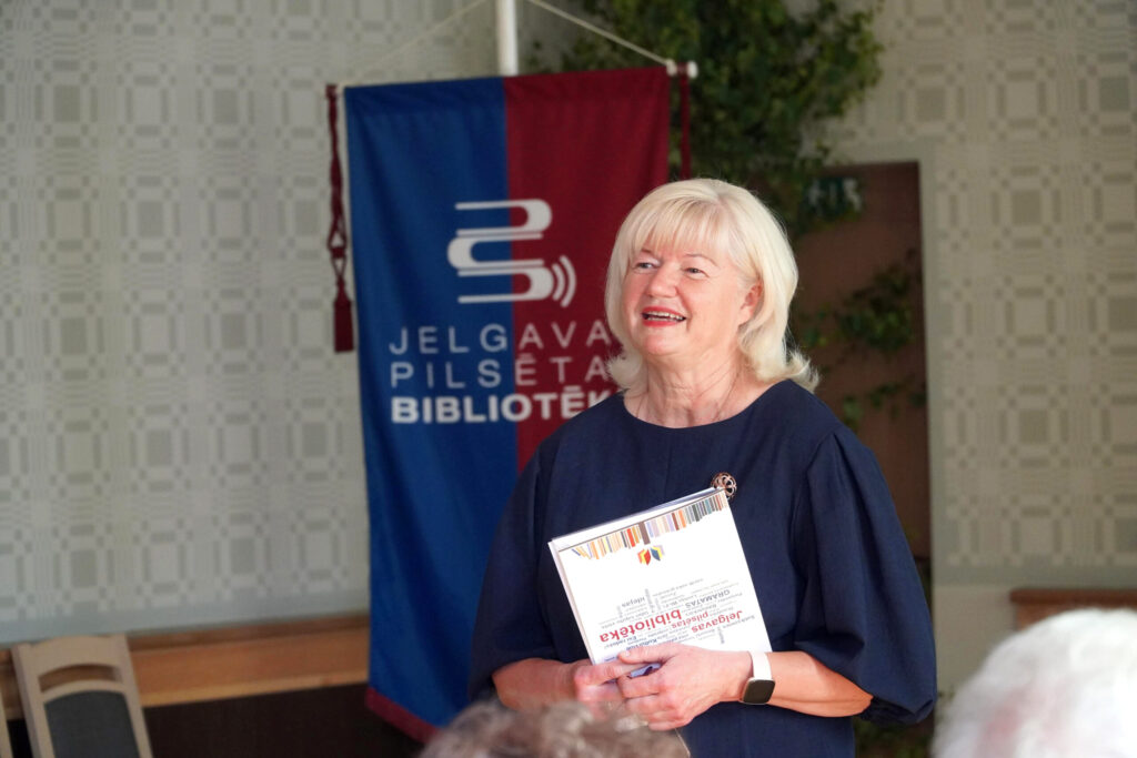 Jelgavas pilsētas bibliotēkas direktore Lāsma Zariņa, uzņemot simpozija viesus, priecājas, ka viens no pasākuma mērķiem ir bibliotēkas 105. dzimšanas dienas atzīmēšana. Foto no JPB arhīva