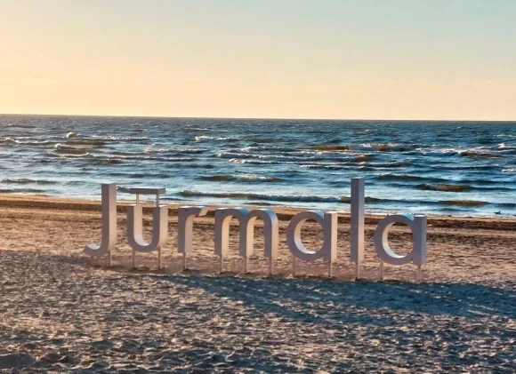 ZEMES STRĒLE starp Lielupi un Rīgas jūras līci vilina. Dubultu klusums kontrastē ar Majoriem, kur pludmalē “gozējas” Jūrmalas uzraksts.