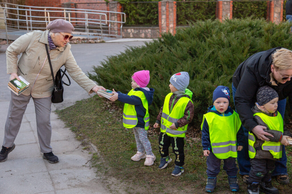 Bibliotēkas lasītāja Sarma Priede un Zaļenieku Komerciālās un amatniecības vidusskolas pirmsskolas prupas “Spārītes” bērni.
